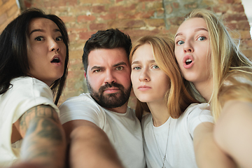 Image showing Group of adorable multiethnic friends having fun at home interior background