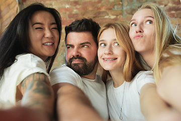 Image showing Group of adorable multiethnic friends having fun at home interior background