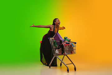 Image showing Portrait of young woman in neon light on gradient backgound. The human emotions, black friday, cyber monday, purchases, sales, finance concept.