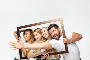 Image showing Group of adorable multiethnic friends having fun isolated over white studio background