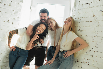 Image showing Group of adorable multiethnic friends having fun at home interior background