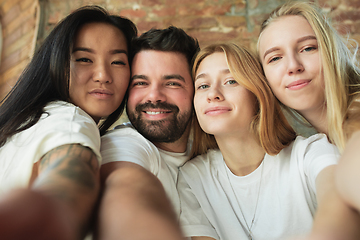 Image showing Group of adorable multiethnic friends having fun at home interior background