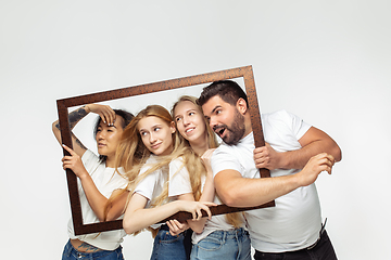 Image showing Group of adorable multiethnic friends having fun isolated over white studio background