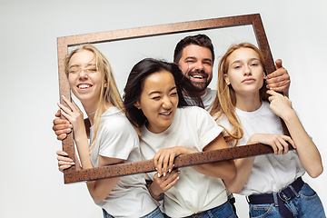 Image showing Group of adorable multiethnic friends having fun isolated over white studio background