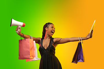 Image showing Portrait of young woman in neon light on gradient backgound. The human emotions, black friday, cyber monday, purchases, sales, finance concept.