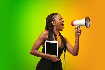 Image showing Portrait of young woman in neon light on gradient backgound. The human emotions, black friday, cyber monday, purchases, sales, finance concept.