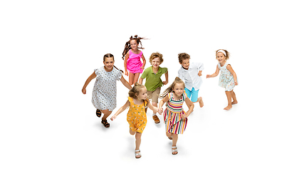 Image showing Happy little caucasian kids jumping and running isolated on white background