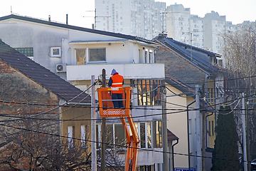 Image showing Electrician worker on a pole, repairing power lines