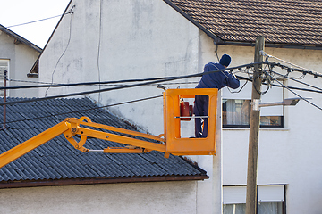 Image showing Electrician worker on a pole, repairing power lines