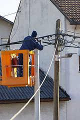 Image showing Electrician worker on a pole, repairing power lines