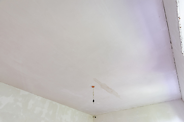 Image showing Plastered ceiling in the room, stains from flooding from above are visible on the ceiling