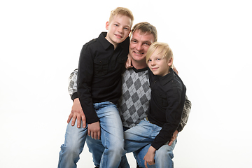 Image showing Half-length portrait of a father and two sons in casual clothes on a white background