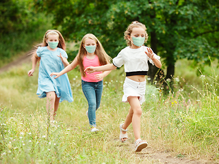 Image showing Happy little caucasian kids jumping and running on the meadow, in forest