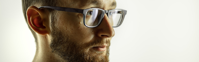 Image showing Caucasian young man\'s close up cropped shot on studio background, flyer