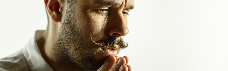 Image showing Caucasian young man\'s close up cropped shot on studio background, flyer