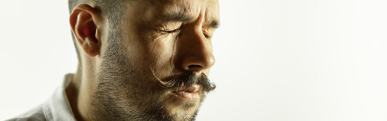 Image showing Caucasian young man\'s close up cropped shot on studio background, flyer