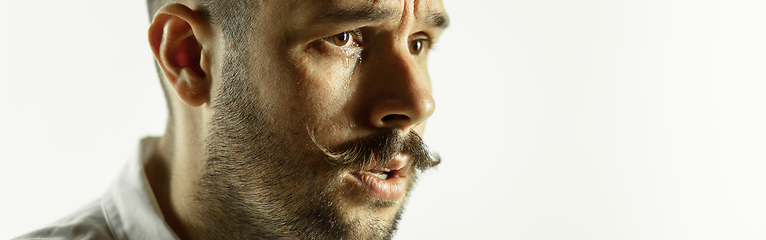 Image showing Caucasian young man\'s close up cropped shot on studio background, flyer