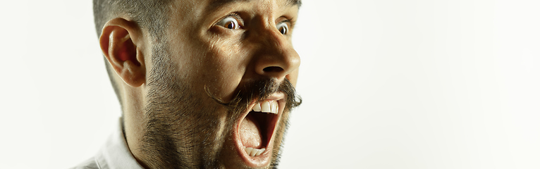 Image showing Caucasian young man\'s close up cropped shot on studio background, flyer