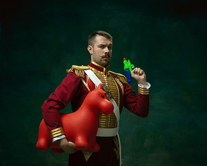 Image showing Young man as Nicholas II on dark green background. Retro style, comparison of eras concept.