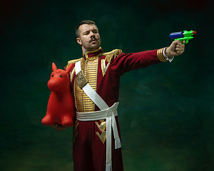 Image showing Young man as Nicholas II on dark green background. Retro style, comparison of eras concept.