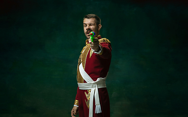 Image showing Young man as Nicholas II on dark green background. Retro style, comparison of eras concept.