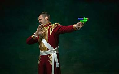 Image showing Young man as Nicholas II on dark green background. Retro style, comparison of eras concept.