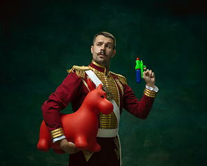 Image showing Young man as Nicholas II on dark green background. Retro style, comparison of eras concept.