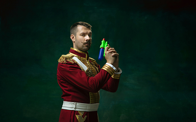 Image showing Young man as Nicholas II on dark green background. Retro style, comparison of eras concept.