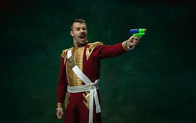 Image showing Young man as Nicholas II on dark green background. Retro style, comparison of eras concept.