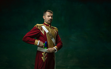 Image showing Young man as Nicholas II on dark green background. Retro style, comparison of eras concept.