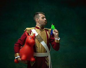 Image showing Young man as Nicholas II on dark green background. Retro style, comparison of eras concept.