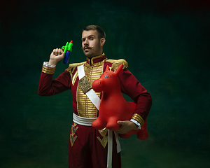 Image showing Young man as Nicholas II on dark green background. Retro style, comparison of eras concept.