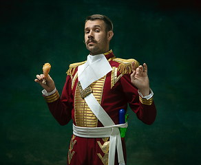 Image showing Young man as Nicholas II on dark green background. Retro style, comparison of eras concept.