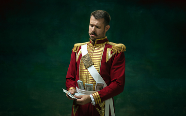 Image showing Young man as Nicholas II on dark green background. Retro style, comparison of eras concept.