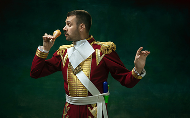 Image showing Young man as Nicholas II on dark green background. Retro style, comparison of eras concept.