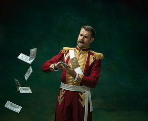 Image showing Young man as Nicholas II on dark green background. Retro style, comparison of eras concept.