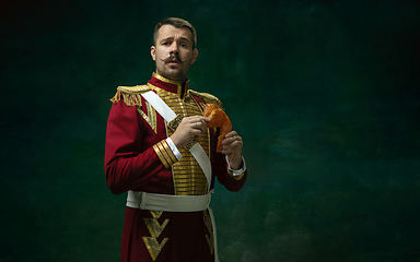 Image showing Young man as Nicholas II on dark green background. Retro style, comparison of eras concept.