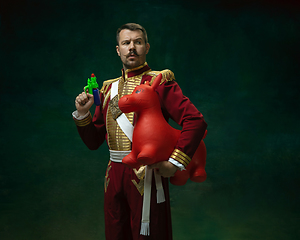 Image showing Young man as Nicholas II on dark green background. Retro style, comparison of eras concept.