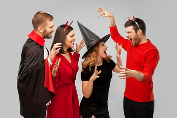 Image showing friends in halloween costumes scaring each other