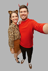 Image showing happy couple in halloween costumes taking selfie