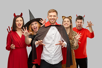 Image showing friends in halloween costumes scaring