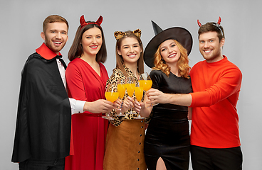 Image showing happy friends in halloween costumes over grey