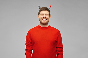 Image showing happy man in halloween costume of devil over grey