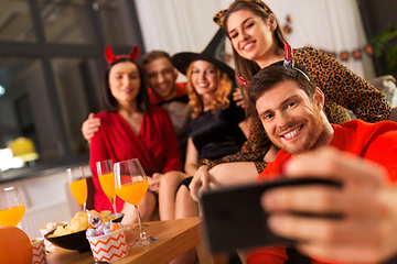 Image showing happy friends in halloween costumes taking selfie