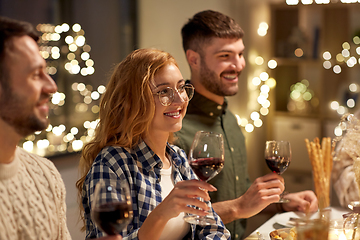 Image showing happy friends drinking red wine at christmas party