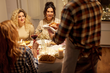 Image showing happy friends having christmas dinner at home