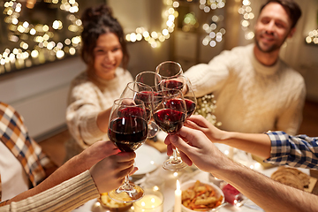 Image showing happy friends drinking red wine at christmas party