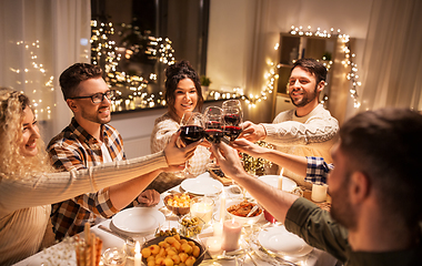 Image showing happy friends drinking red wine at christmas party