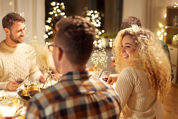 Image showing happy friends having christmas dinner at home