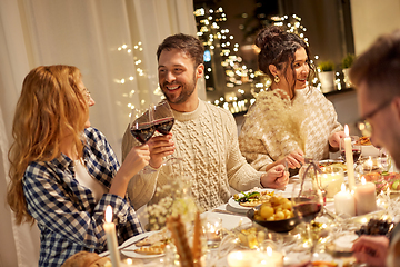 Image showing happy friends drinking red wine at christmas party